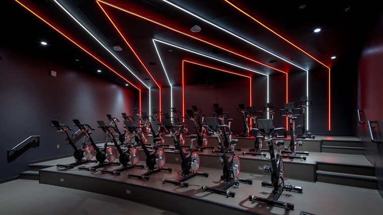 Stationary bike cycling studio with lines of light going up the wall and across the ceiling