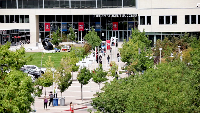 aerial view of people walking on sidewalk leading to building