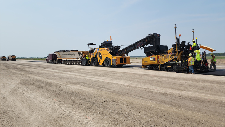 construction vehicles paving runway