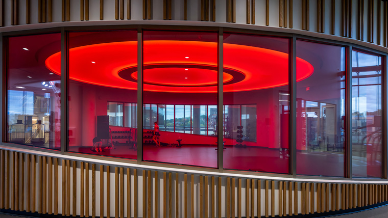 Exterior of Halo Studio, view through window of room with red glow from circular ceiling light