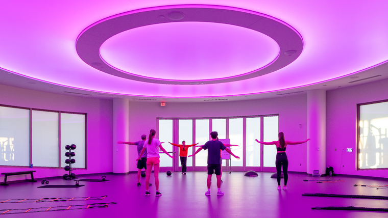 Interior of Halo Studio, purple glow from ceiling light with people in middle of room