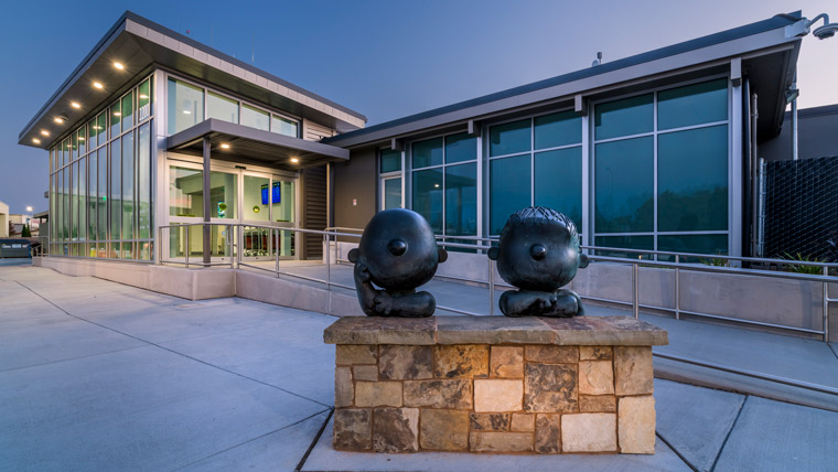 Exterior of Charles M Schulz Sonoma Airport with bronze statue of Charlie Brown and Lucy