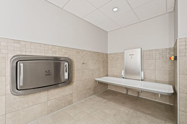 An adult-sized powered changing table in an accessible restroom at Fort Wayne International Airport. 
