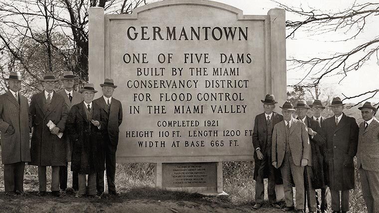 Daniel Mead and company stand in front of Miami Valley signage