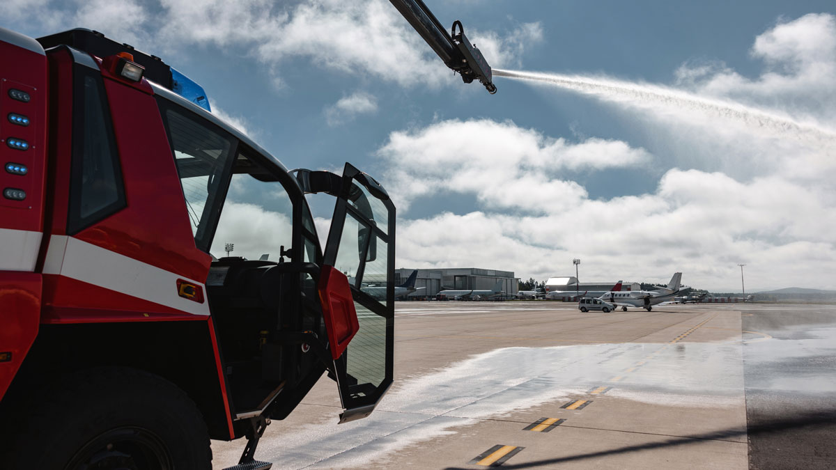 a fire truck sprays foam on an airport runway