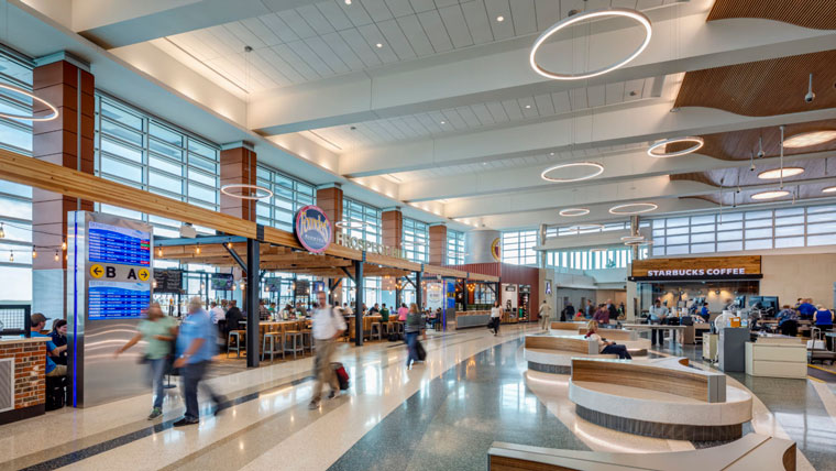 view of busy airprt terminal showing natural light, soft lighting and wood details