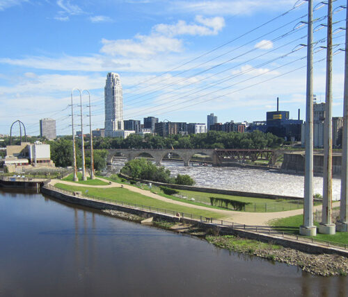 cityscape with body of water in foreground with dam to the right