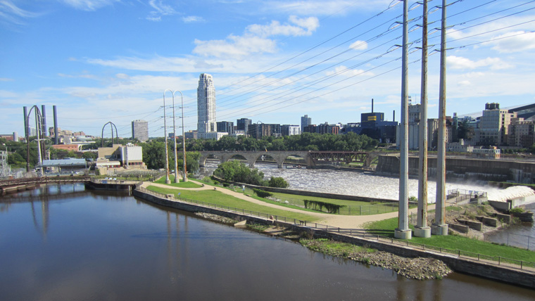 cityscape with body of water in foreground with dam to the right