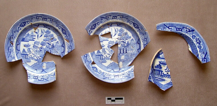 three partial blue and white plates pieced together from fragments