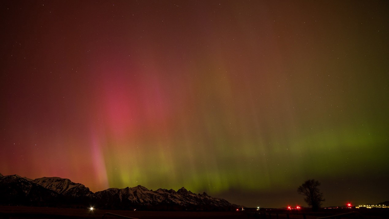 Night sky lit with pink and green northern lights