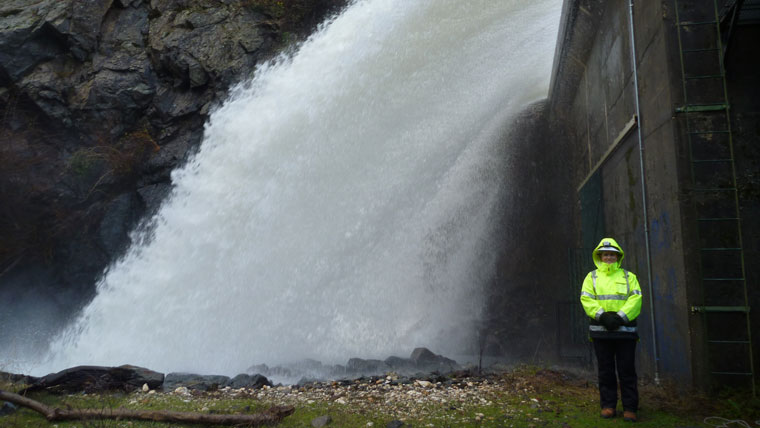 Engineer Jackie Hader stands in front of active spillway