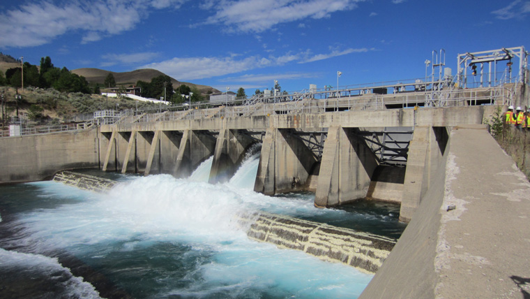 dam with rushing water flowing into waterway below