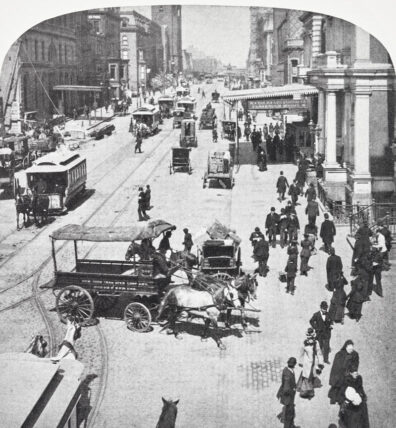 close up black and white photo of busy city street showing hoses and cars