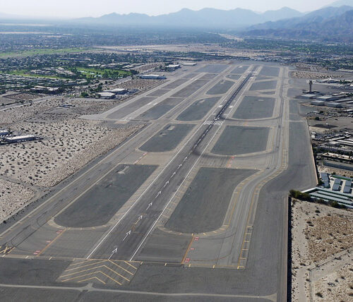 aerial view of taxiway and runway with mountains in the background