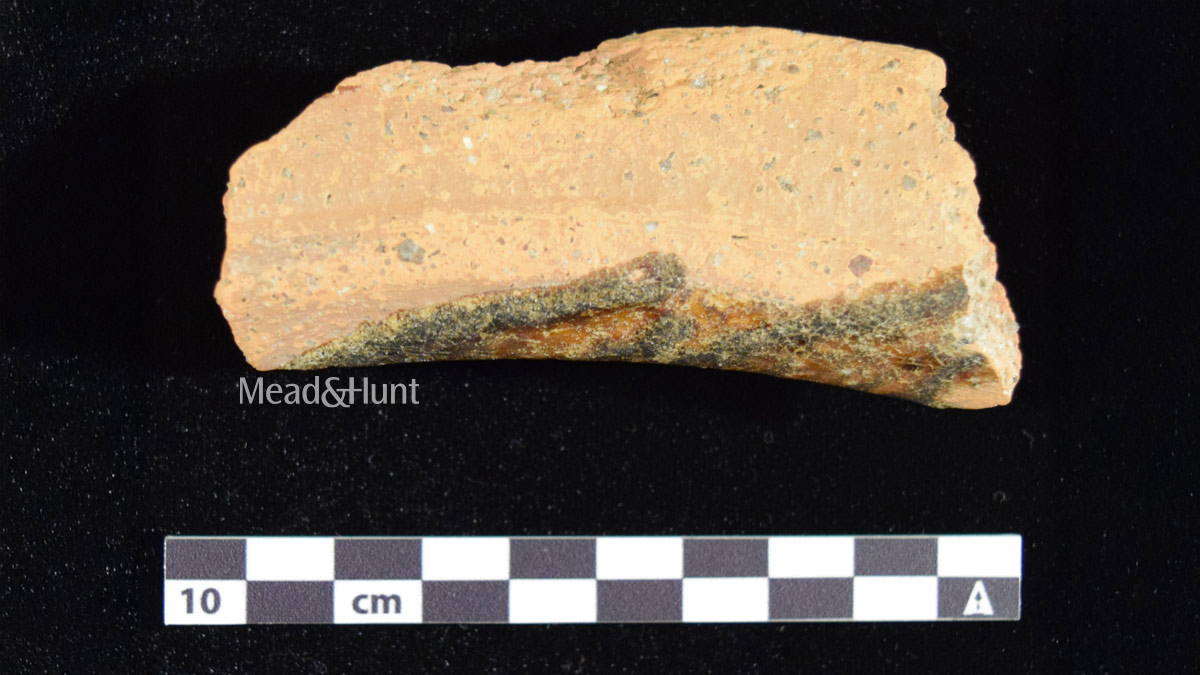 Historical gravel sherd next to a measuring stick