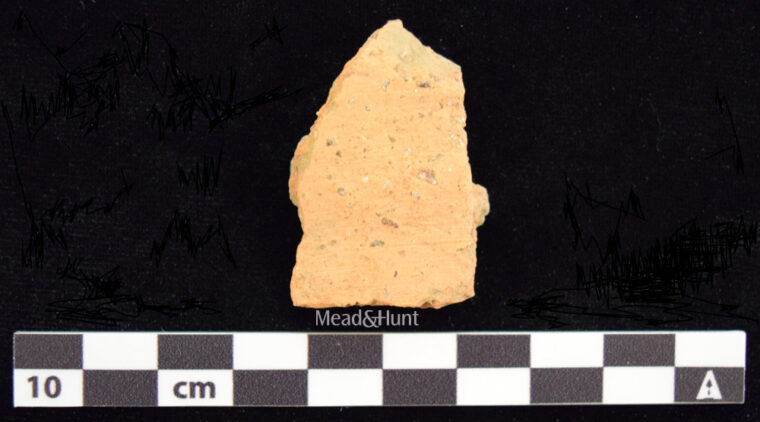 Historical gravel sherd next to a measuring stick