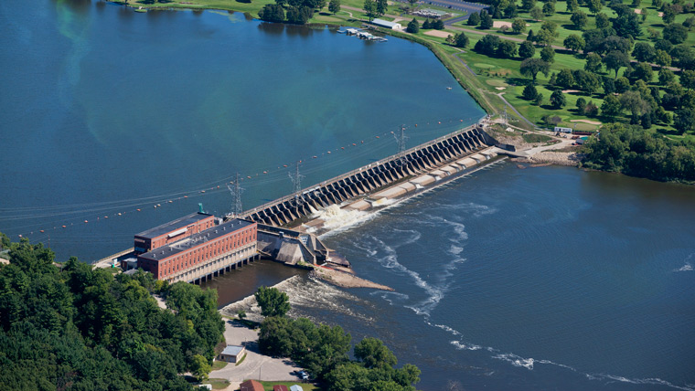 aerial view of a dam across a waterway with some water flowing through