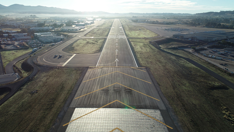 aerial view of runway spanning vertically and sun shining in background