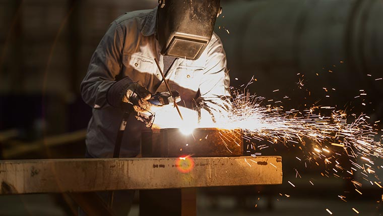 Steel fabricator works with welding equipment