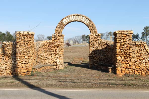 an old stone wall with an arched opening in the middle that says Mt. Horeb.