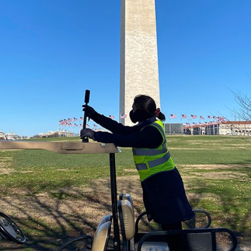 Woman in safety attire collecting GIS data at National Mall