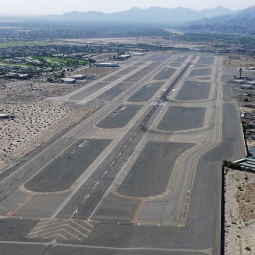 aerial view of taxiway and runway with mountains in the background