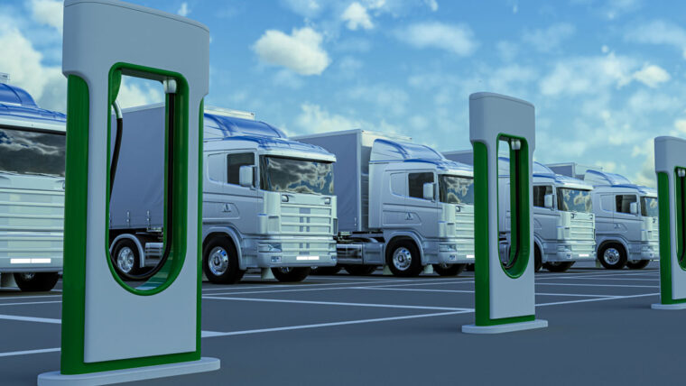 five large trucks parked near EV chargers