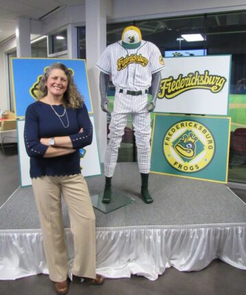 Kerri stands in front of the Frogs mannequin display