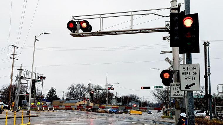 a busy intersection with a traffic light and railroad crossing