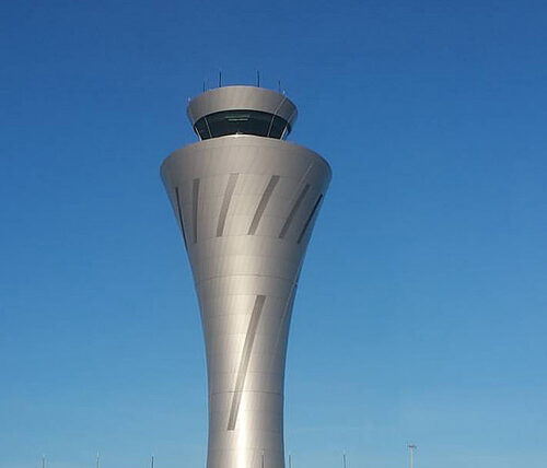 the air traffic control tower against a clear blue sky