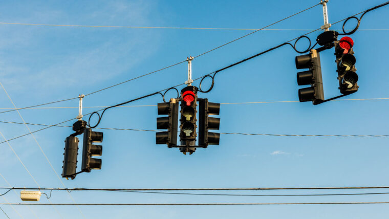 three sets of traffic signals hang on a wire
