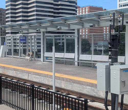 view across a metro rail, looking at the train stop with seating