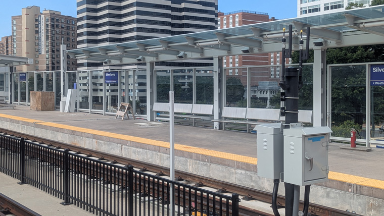 view across a metro rail, looking at the train stop with seating
